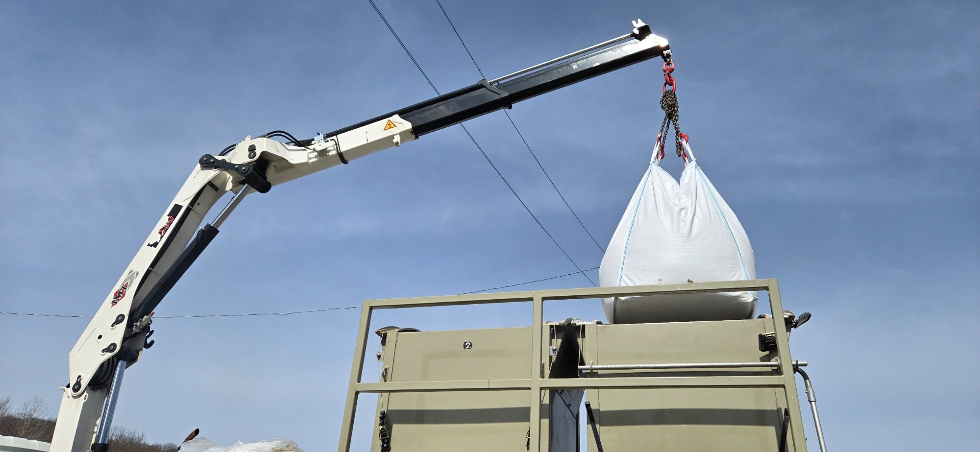 Crane lifting bag at industrial site
