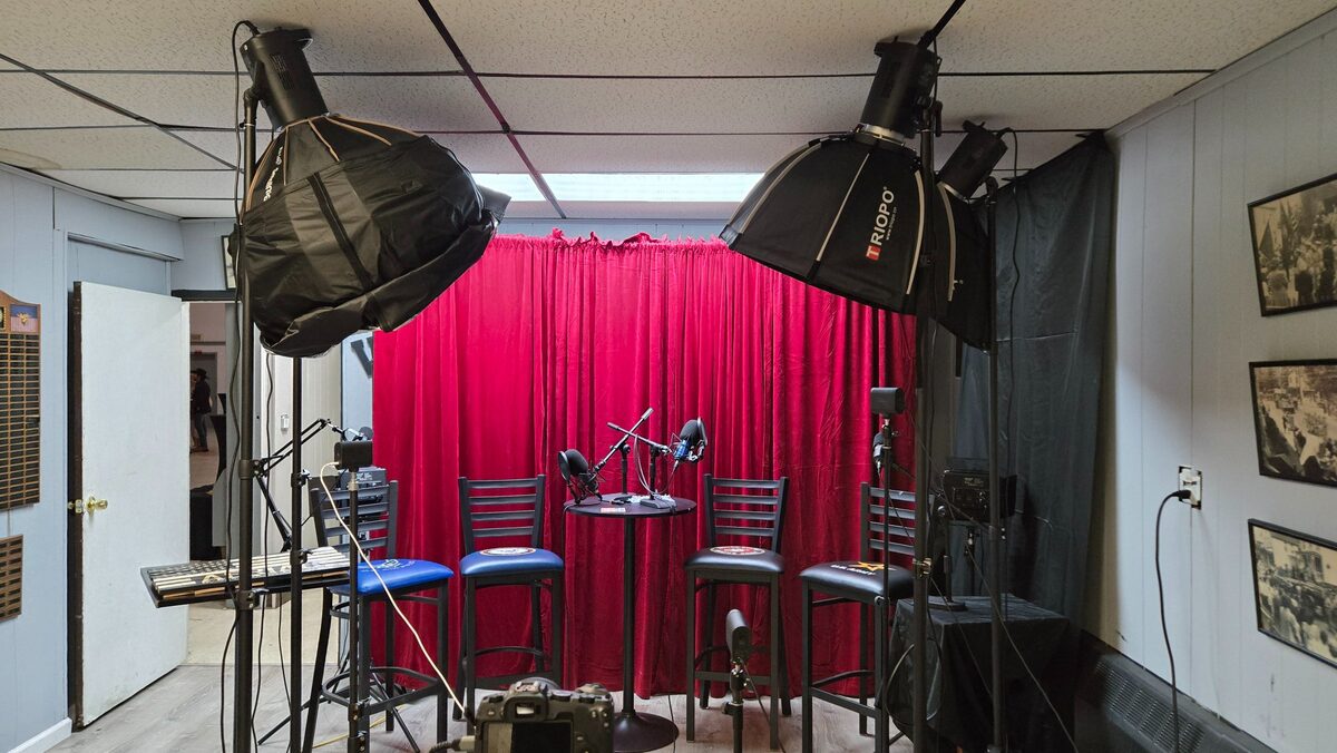 Podcast and interview studio setup with red curtain backdrop